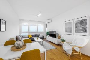 Una sala de estar con una mesa y sillas blancas. en Panta Rhei Luxury Apartments, en Novi Sad