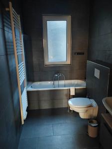 baño con bañera, aseo y ventana en Modernes Juwel in Hagen City, en Hagen