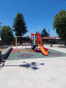 a playground with a slide in a park at Departamento interior 2 Villarrica Céntrico in Villarrica