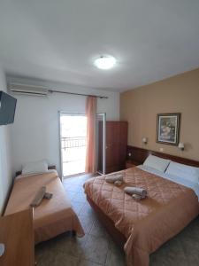 two beds in a room with a window at Aleka apartment 5 in Agios Georgios