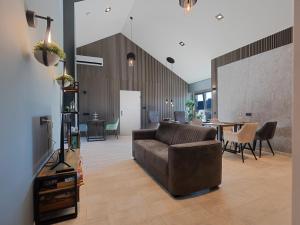 a living room with a couch and a table at Luxe kamer B&B Gezond aan Zee, met jacuzzi en stoomsauna, de wellnestuin buiten is te huur voor privé gebruik tegen meerprijs in Ouddorp