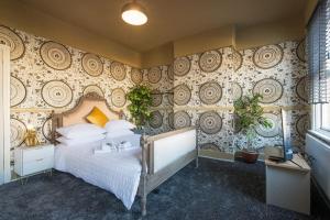 - une chambre avec un grand lit dans une pièce avec un mur dans l'établissement Deluxe 4 Bed London House Nr Stratford, à Londres