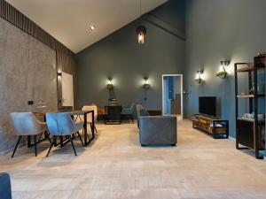 a living room with a table and chairs at Luxe kamer B&B Gezond aan Zee, met jacuzzi en stoomsauna, de wellnestuin buiten is te huur voor privé gebruik tegen meerprijs in Ouddorp