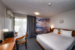 a hotel room with a bed and a desk and a computer at Clarion Pointe La Malbaie in La Malbaie