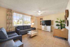a living room with a couch and a tv at Coconut Bay Resort in Fort Lauderdale