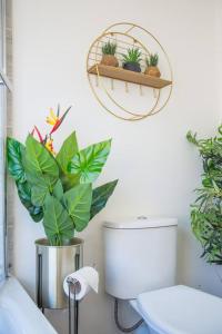 a bathroom with a toilet and plants on the wall at Deluxe 4 Bed London House Nr Stratford in London