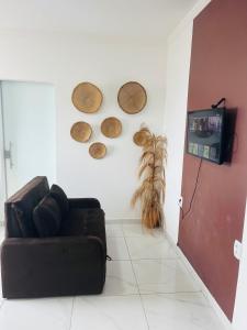 NOVO APARTAMENTO Liz 1 في بورتو سيغورو: غرفة معيشة مع أريكة وتلفزيون على الحائط