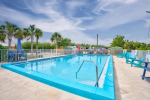 a blue swimming pool with blue chairs and palm trees at Cabins at Bonefish Bay in Marathon