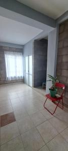 a room with a red chair and a potted plant at Alto Bustamante in San Salvador de Jujuy