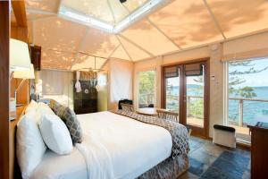 um quarto com uma cama grande e uma janela grande em Rockwater Secret Cove Resort em Sechelt