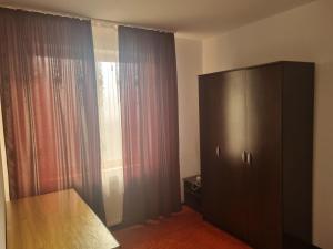 a bedroom with a dresser and a large window at Apartament Unirii Belvedere in Baia Mare