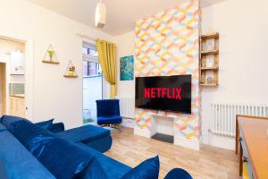 a living room with a blue couch and a television at 3BR Home with Free Parking in Spon End