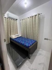 ein kleines Zimmer mit einem Bett in der Ecke in der Unterkunft Camella Cerritos Gensan in General Santos