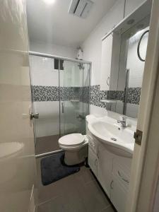 a bathroom with a shower and a toilet and a sink at Camella Cerritos Gensan in General Santos
