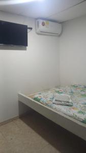 łóżko w pokoju ze ścianą w obiekcie hotel casa del conductor doña silvia w mieście Cartagena de Indias