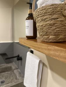 a bottle of soap and a basket on a shelf in a bathroom at Pachamaya - Suites, Wellness & Spa, Retreats in Cancún