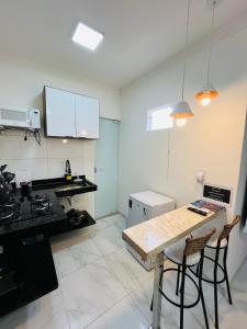 a kitchen with a table and chairs in a room at NOVO APARTAMENTO Liz 3 in Porto Seguro