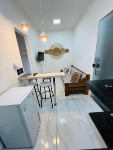 uma cozinha com uma mesa e um sofá num quarto em NOVO APARTAMENTO Liz 3 em Porto Seguro