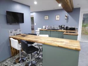 a kitchen with blue walls and a wooden counter top at La fermette paisible proche du Mont Saint-Michel in Saint-James