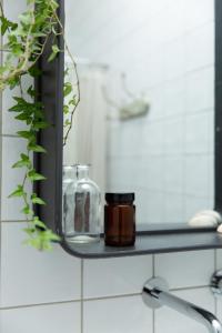 - une étagère dans la salle de bains avec un pot en verre et un miroir dans l'établissement Chambre avec salle de bain et accès indépendant, à Nantes
