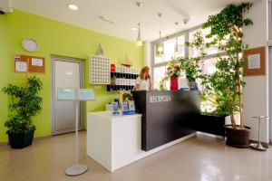 a woman standing at a counter in a store at Hotel Novi in Herceg-Novi