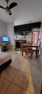 a living room with a table and chairs and a kitchen at Apartamento Boqueirão - Praia Grande in Praia Grande