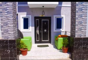 a front door of a house with green furniture at D'EXQUISITE APARTMENTS in Ibadan