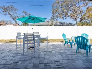a patio with a table and chairs and an umbrella at Venice 3 Bedroom Luxury Home, Completely Renovated, 5 Star Rated - 10Mins to Beaches in Venice