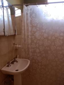 a bathroom with a sink and a shower curtain at SOL Y LAGO in Villa Carlos Paz