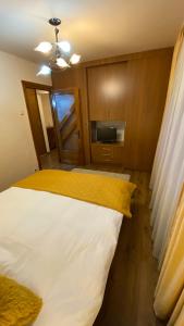 a bedroom with a bed with a yellow blanket at Apartament doua camere in Baia Mare