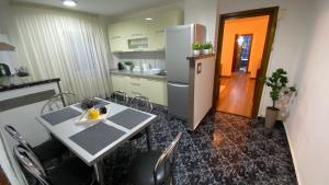 a kitchen with a table and a refrigerator at Apartament doua camere in Baia Mare