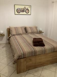 Una cama con dos toallas marrones encima. en NeMapartment en Athens