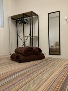 - une pile de serviettes brunes sur un lit dans la chambre dans l'établissement NeMapartment, à Athènes