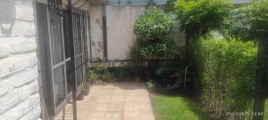 una entrada a un jardín con una puerta y plantas en Alquiler Temporada Casa 2 dormitorios para 6 personas en Mar del Plata
