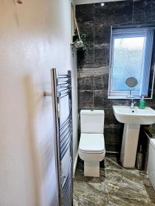 a bathroom with a toilet and a sink at B43 Cosy Home - Contractor-Family Stays Near Bhm City-Off Road Parking Free Wi-fi in Holly Lane