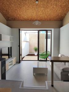 a living room with a table and a green chair at VUELVE apartamentos in Fuente de Cantos