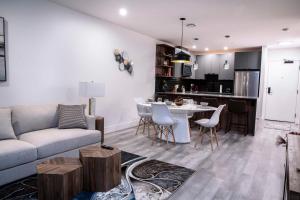 sala de estar y cocina con sofá y mesa en Revelstoke Marvel - Two Bedroom with Hot Tub en Revelstoke