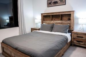 a bedroom with a bed with a wooden headboard at Revelstoke Marvel - Two Bedroom with Hot Tub in Revelstoke