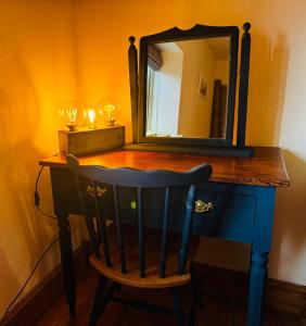 a mirror on top of a dresser with a chair at Nightingale Cottage in Llantwit Major