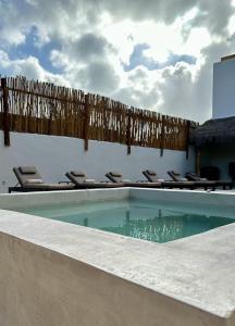 坎昆的住宿－Pachamaya - Suites, Wellness & Spa, Retreats，游泳池周围摆放着一堆椅子