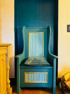 a blue chair with a mirror on a blue wall at Nightingale Cottage in Llantwit Major