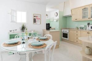 a kitchen with a white table and chairs in a room at GeDel Ma Zen Resort in Poris de Abona