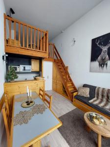 salon ze stołem i kanapą w obiekcie RESIDENCE LE RUITOR Duplex dernier étage vue panoramique piscine chauffée en été classé 4 Cristaux Paradiski w mieście Arc 1800