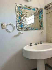 bagno con lavandino e specchio di El Ocaso Villa Giardino a Villa Giardino