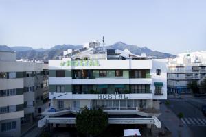 a white building with a hospital sign on it at Hostal Alhambra - Adults Only in Nerja