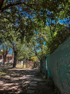 una recinzione accanto a un campo alberato di El Ocaso Villa Giardino a Villa Giardino
