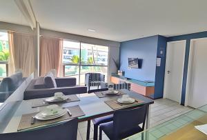 comedor y sala de estar con mesa y sillas en Na Praia Flats Ancorar, en Porto de Galinhas