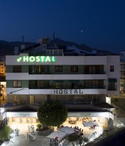 ein Krankenhausgebäude mit einem Schild am Abend in der Unterkunft Hostal Alhambra - Adults Only in Nerja