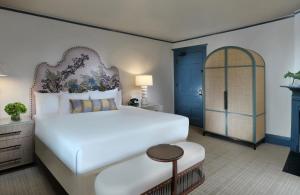 a bedroom with a large white bed and a blue door at Jekyll Island Club Resort in Jekyll Island