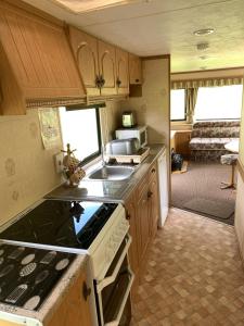 a kitchen with a stove and a sink in a caravan at Sandpiper Caravan in Onich